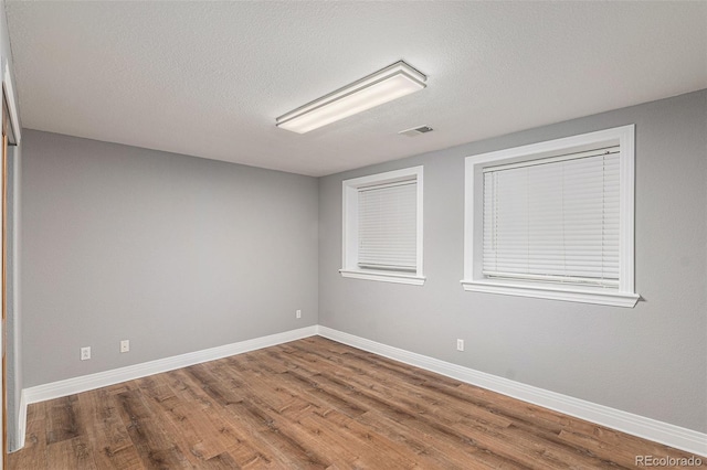 empty room featuring hardwood / wood-style floors and a textured ceiling