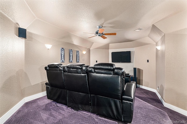 carpeted home theater room with ceiling fan, lofted ceiling, and a textured ceiling