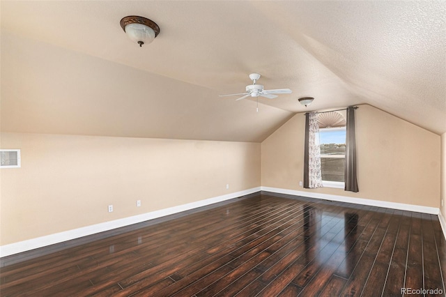 additional living space with hardwood / wood-style floors, ceiling fan, a textured ceiling, and vaulted ceiling