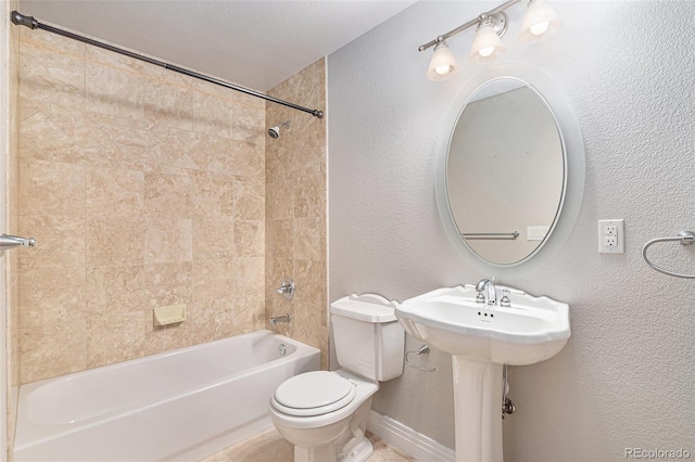 bathroom featuring tiled shower / bath, a textured ceiling, and toilet