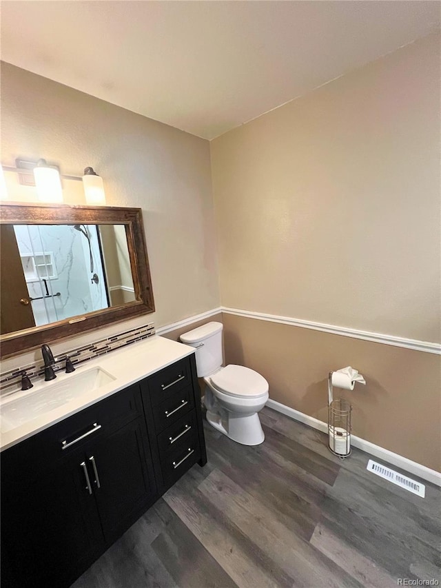 3415 S Ammons St Unit 24-2, Lakewood, CO 80227 - bathroom with wood finished floors, a marble finish shower, toilet, vanity, and baseboards