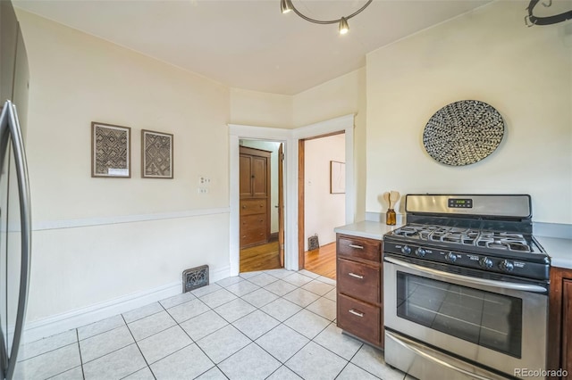3024 W Denver Pl, Denver, CO 80211 - kitchen with gas stove, light tile patterned flooring, freestanding refrigerator, and light countertops