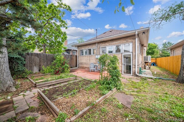 3024 W Denver Pl, Denver, CO 80211 - back of property featuring a garden, a patio area, and a fenced backyard