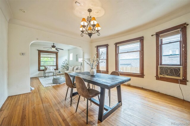 3024 W Denver Pl, Denver, CO 80211 - dining space with arched walkways, light wood finished floors, a chandelier, a ceiling fan, and cooling unit