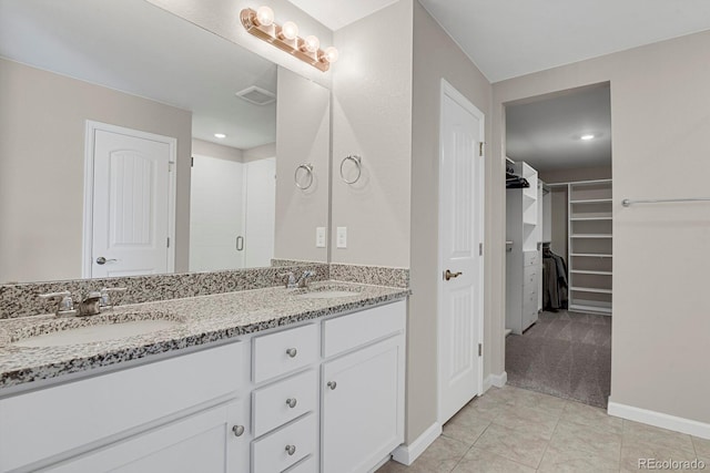 5166 Trails Edge Ln, Castle Rock, CO 80104 - bathroom with double vanity, a spacious closet, a stall shower, baseboards, and tile patterned flooring