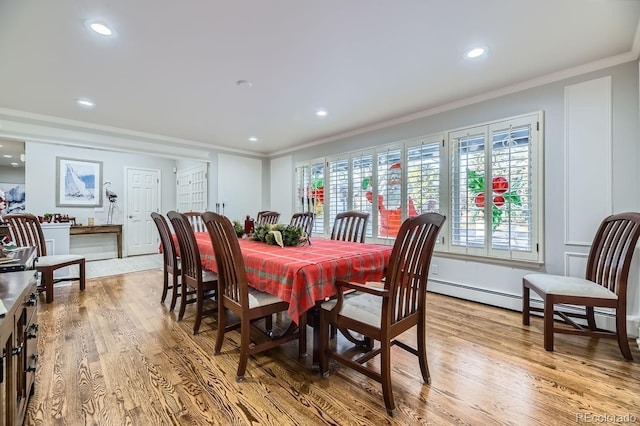 dining room featuring light wood-type flooring, a baseboard radiator, and ornamental molding