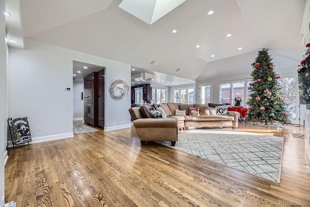 living room with vaulted ceiling with skylight and wood-type flooring