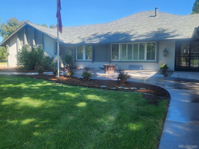 rear view of house featuring a lawn and a patio