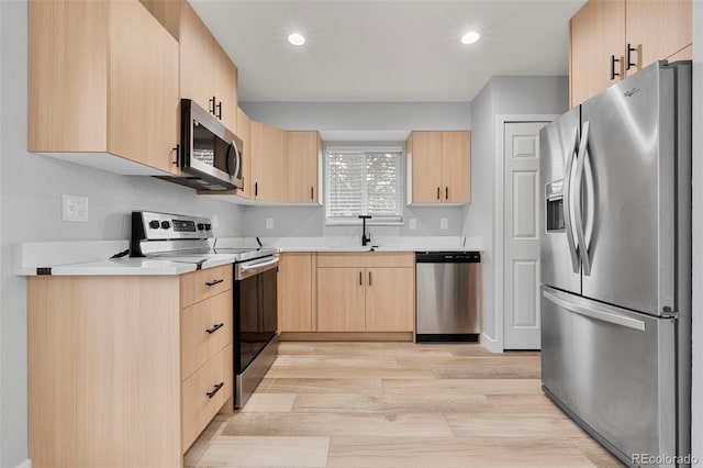 kitchen with sink, light wood-type flooring, stainless steel appliances, and light brown cabinetry