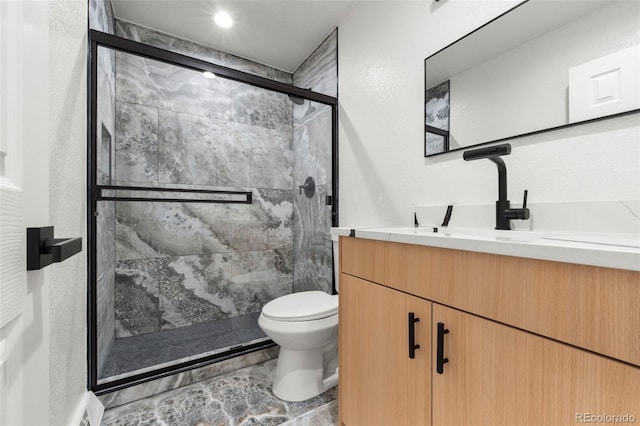 bathroom featuring vanity, toilet, and an enclosed shower