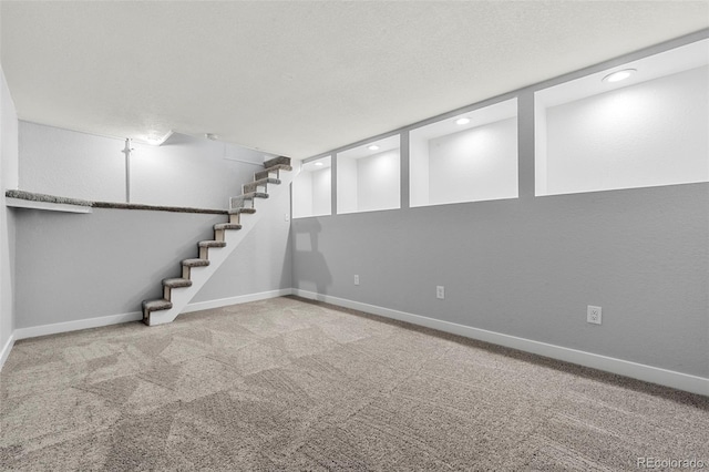 basement featuring carpet floors and a textured ceiling