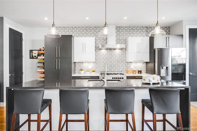 3617 Shoshone St, Denver, CO 80211 - kitchen with wall chimney range hood, stainless steel fridge, decorative backsplash, modern cabinets, and a breakfast bar area