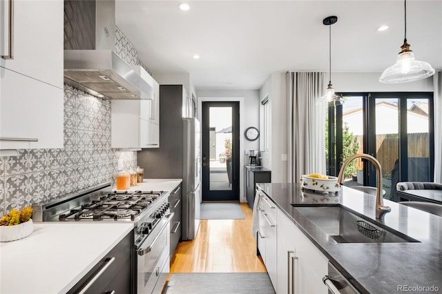 3617 Shoshone St, Denver, CO 80211 - kitchen featuring stainless steel appliances, wall chimney exhaust hood, light wood-style floors, healthy amount of natural light, and recessed lighting