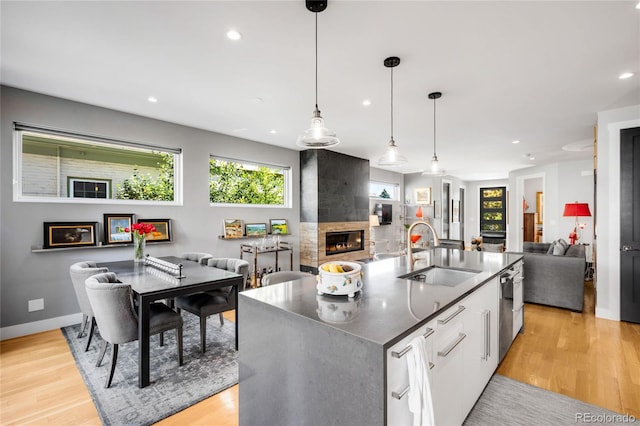 3617 Shoshone St, Denver, CO 80211 - kitchen with open floor plan, a large fireplace, white cabinets, light wood finished floors, and recessed lighting