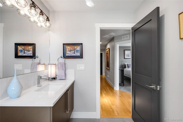 3617 Shoshone St, Denver, CO 80211 - bathroom with vanity, decorative backsplash, and wood finished floors