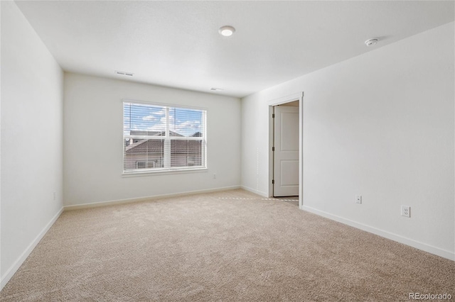 spare room featuring light colored carpet