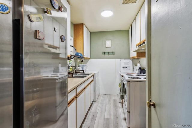 4401 Highline Pl, Denver, CO 80222 - kitchen with white range with electric stovetop, freestanding refrigerator, under cabinet range hood, light wood-type flooring, and light countertops