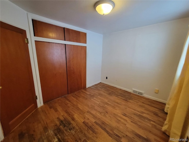 unfurnished bedroom featuring hardwood / wood-style flooring and a closet