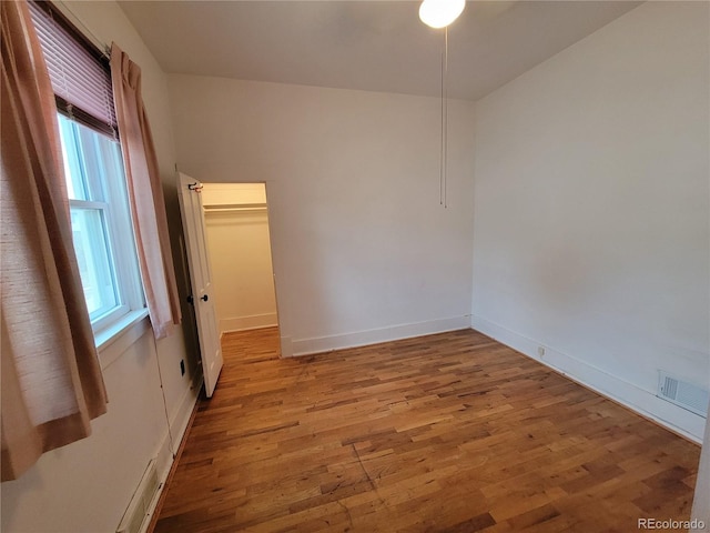 unfurnished room featuring wood-type flooring and plenty of natural light