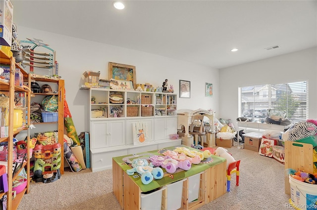 recreation room with light colored carpet