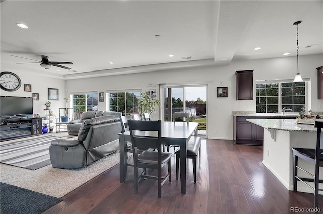 dining area with ceiling fan, sink, and dark hardwood / wood-style flooring