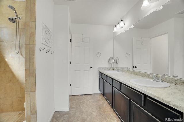 bathroom featuring a tile shower and vanity