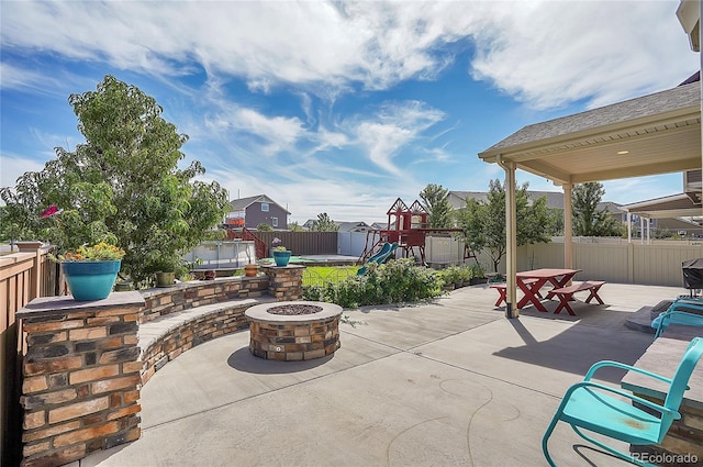 view of patio / terrace featuring a playground and an outdoor fire pit