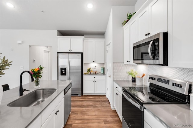 2080 Autumn Moon Dr Unit 5, Windsor, CO 80550 - kitchen featuring stainless steel appliances, a sink, light wood finished floors, white cabinets, and decorative backsplash