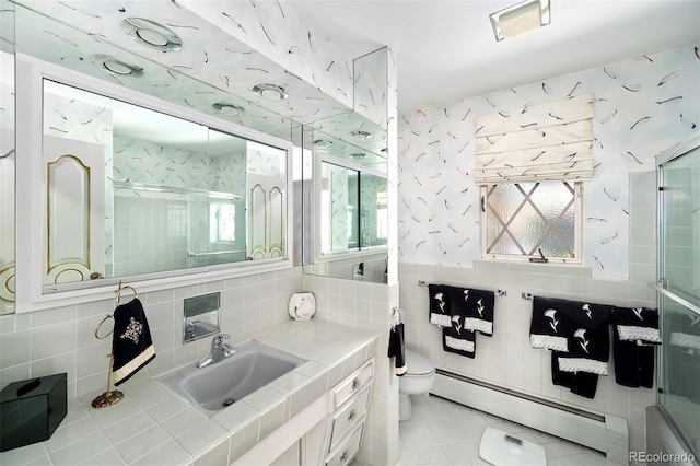 bathroom featuring wallpapered walls, a baseboard radiator, a healthy amount of sunlight, and a shower with shower door