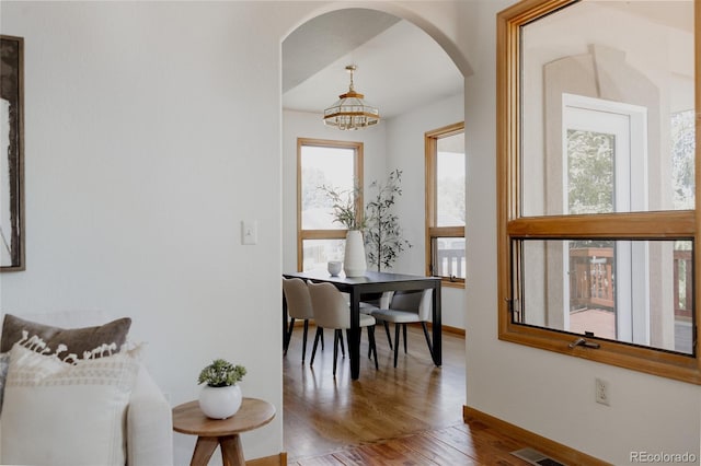 1131 N 4th St, Johnstown, CO 80534 - dining space featuring arched walkways, wood finished floors, and a chandelier