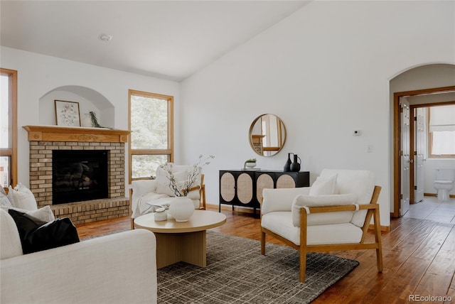 1131 N 4th St, Johnstown, CO 80534 - living room with dark wood-style floors, a fireplace, lofted ceiling, and arched walkways
