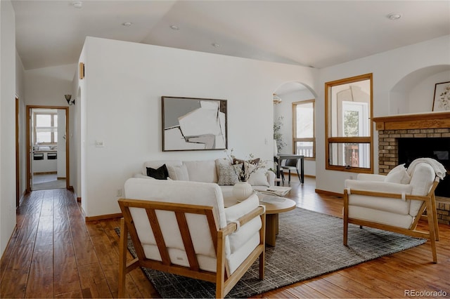 1131 N 4th St, Johnstown, CO 80534 - living area featuring wood-type flooring, arched walkways, vaulted ceiling, and a fireplace