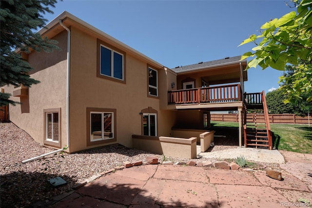 1131 N 4th St, Johnstown, CO 80534 - rear view of house featuring stucco siding, a patio area, stairway, and a deck