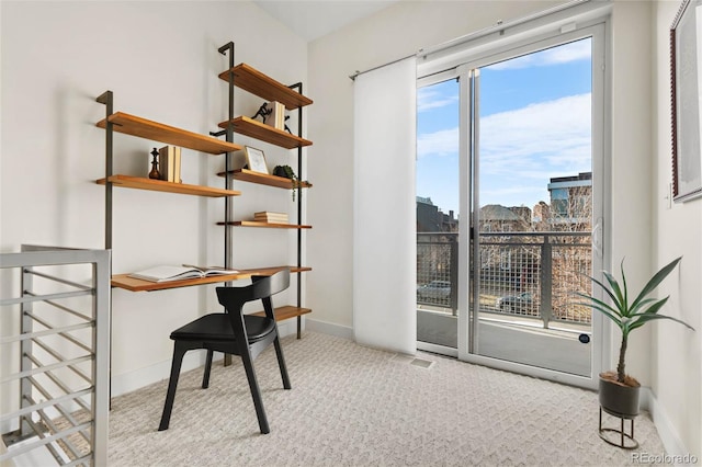 office space featuring visible vents, baseboards, a city view, and carpet flooring