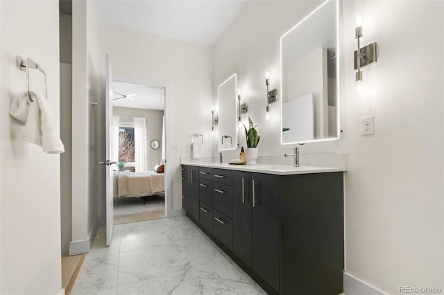 bathroom with a sink, connected bathroom, marble finish floor, and double vanity