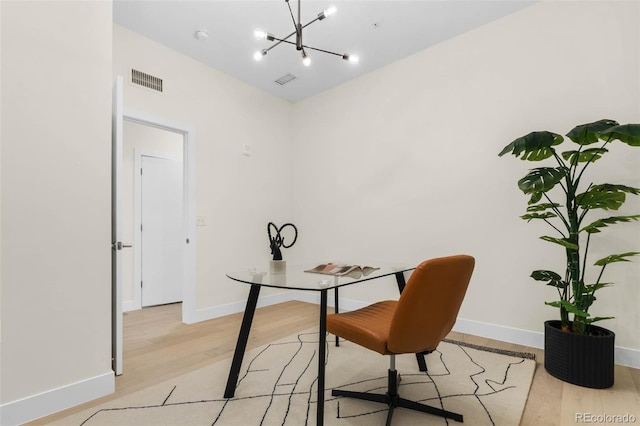 office area featuring a chandelier, visible vents, light wood-style flooring, and baseboards