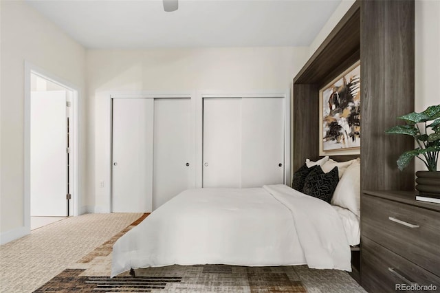 bedroom featuring carpet and multiple closets