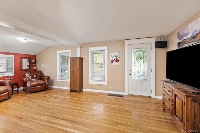 6480 W 60th Ave, Arvada, CO 80003 - living area featuring light wood finished floors, healthy amount of natural light, lofted ceiling, and baseboards