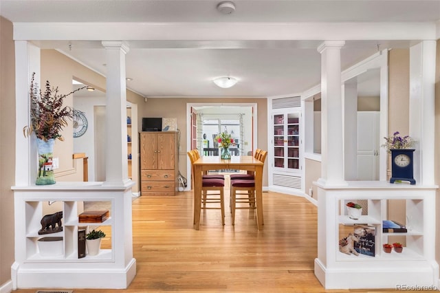 6480 W 60th Ave, Arvada, CO 80003 - dining room with light wood-style flooring, ornate columns, ornamental molding, and built in shelves