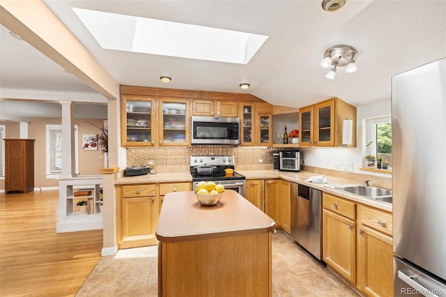 6480 W 60th Ave, Arvada, CO 80003 - kitchen with stainless steel appliances, a skylight, light countertops, a center island, and backsplash