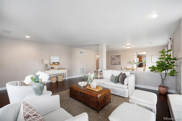 living area with visible vents, baseboards, and wood finished floors