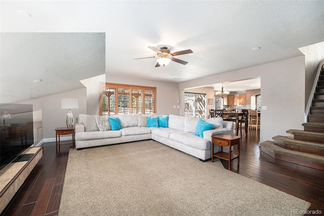 living area with stairway, wood-type flooring, a textured ceiling, and ceiling fan with notable chandelier