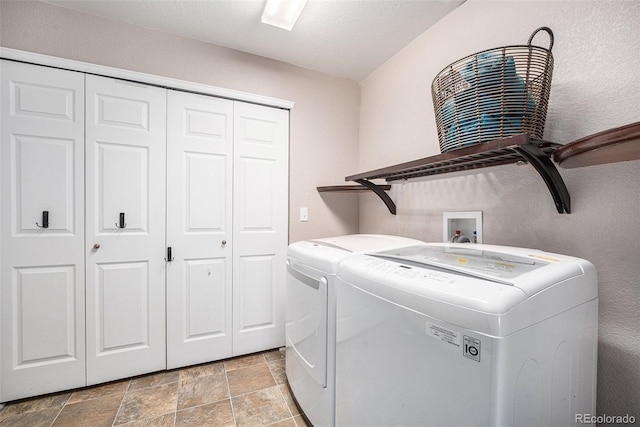 laundry room with washer and clothes dryer, laundry area, and stone finish floor