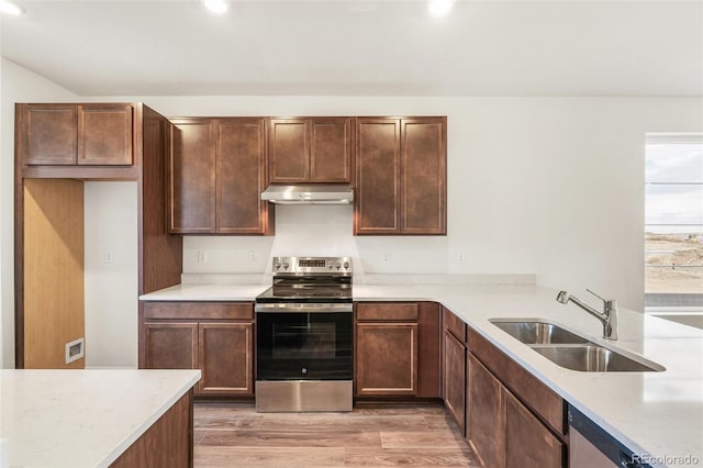 kitchen with appliances with stainless steel finishes, light hardwood / wood-style floors, and sink