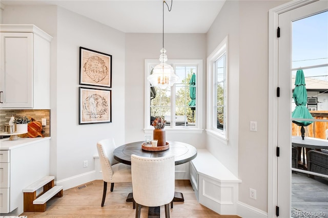 dining room with baseboards, visible vents, and light wood-style flooring