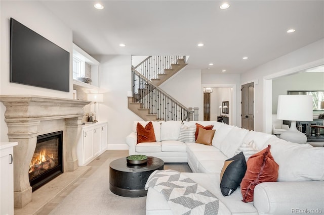 living room featuring recessed lighting, a high end fireplace, baseboards, and stairway