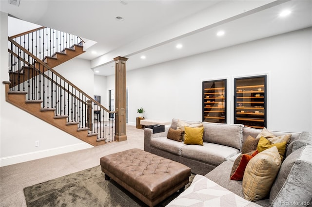 carpeted living room with visible vents, stairway, baseboards, recessed lighting, and ornate columns