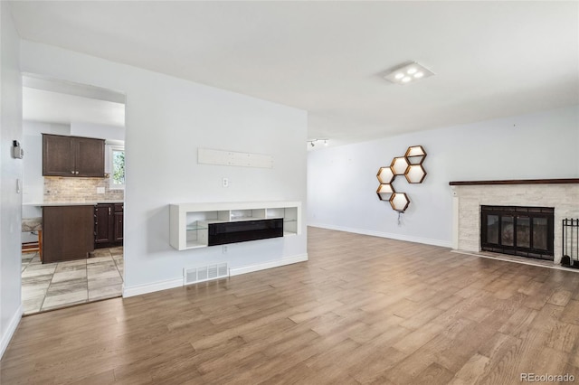 4860 S Field Way, Littleton, CO 80123 - unfurnished living room with a glass covered fireplace and light wood finished floors
