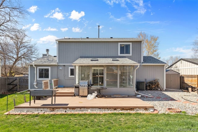 4860 S Field Way, Littleton, CO 80123 - back of house featuring a wooden deck, a fenced backyard, a storage unit, a sunroom, and a shingled roof