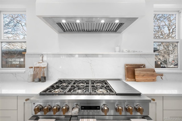 kitchen with range, backsplash, and wall chimney range hood